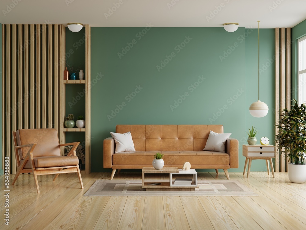 客厅，空的深绿色墙壁背景上有皮沙发和皮扶手椅。