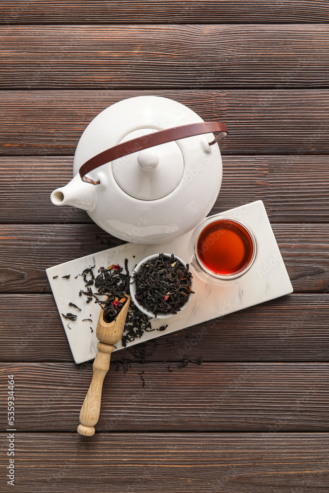 茶壶、一杯红茶和木底干叶