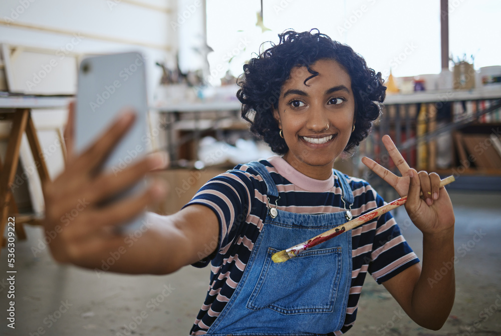 印度女艺术家，在工作室工作室的地板上用画笔和艺术自拍，分享给社会