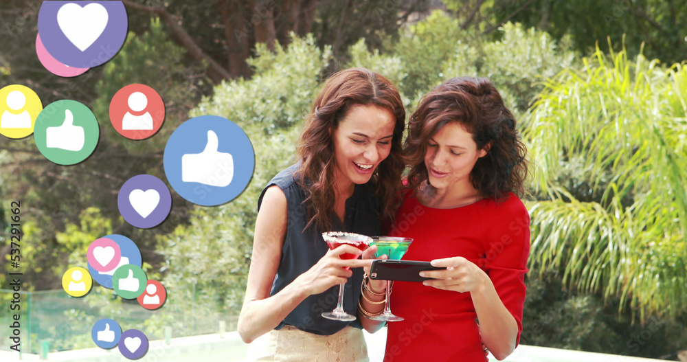 Image of social media reactions and happy caucasian women with smartphone and drinks
