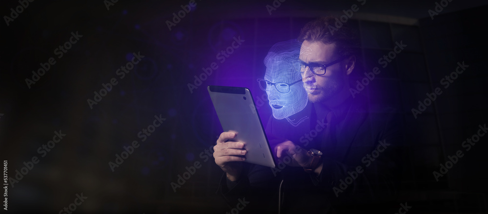 年轻的商人，拿着平板电脑，在黑暗的背景下进行数字投影。挖掘的概念