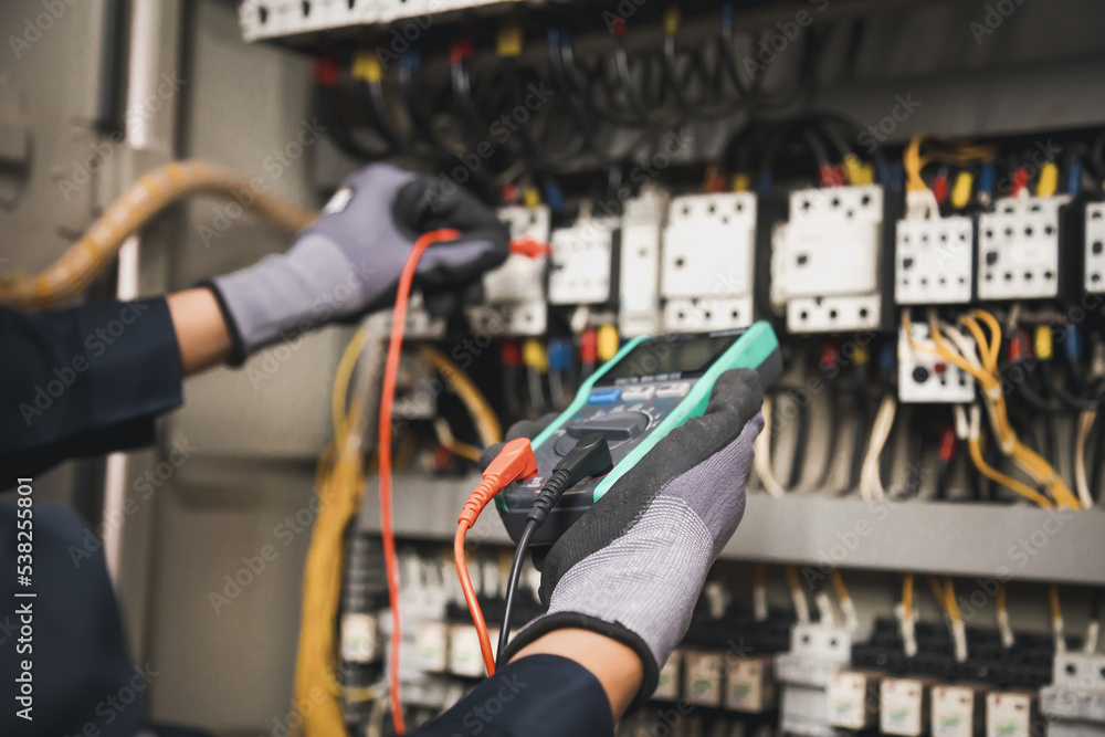 电力和电气维修服务，工程师手持交流万用表检查电气