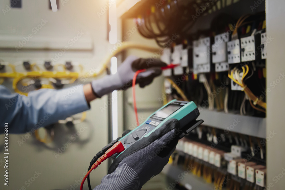 Electricity and electrical maintenance service, Engineer hand holding AC multimeter checking electri