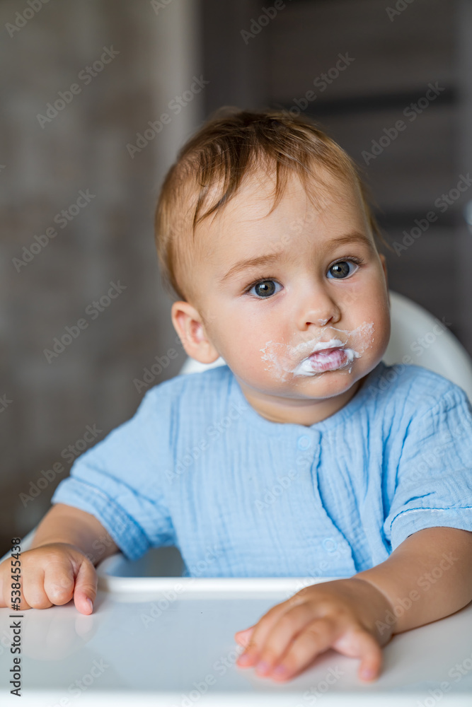 Cute little boy eating porridge. Young kid having breakfast.