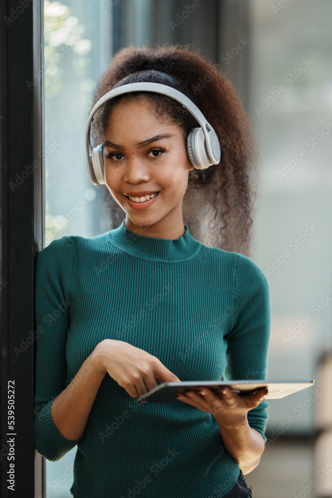 smiling African American woman wearing headphones chatting online, video call.
