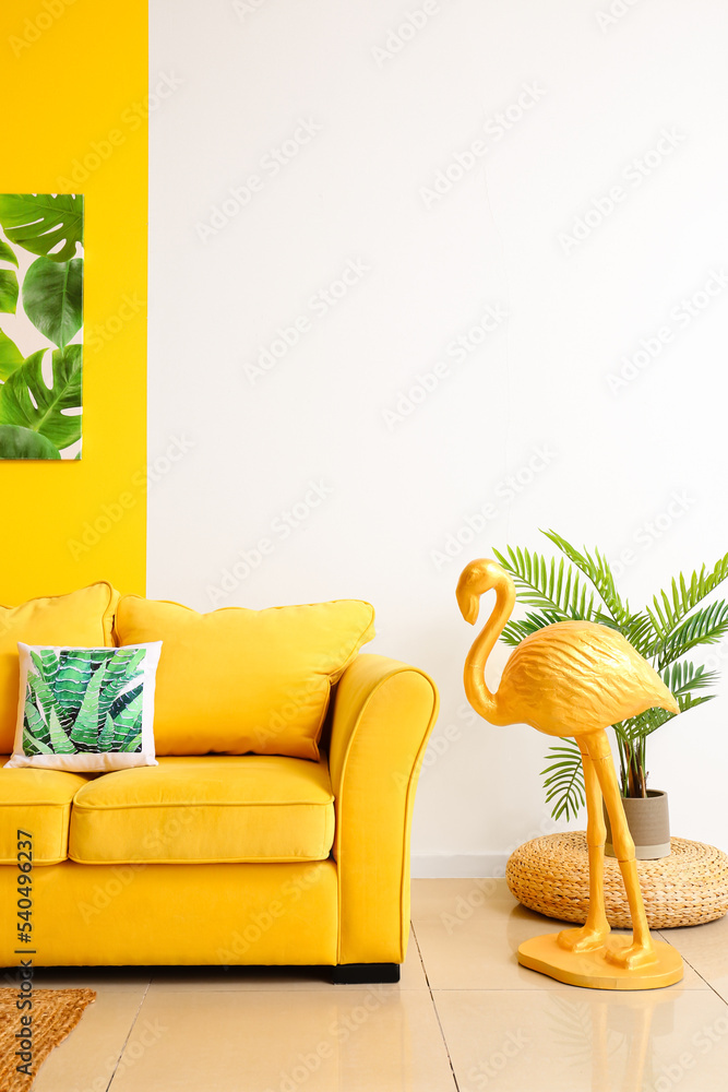 舒适的沙发、火烈鸟和房间内部彩色墙附近的绘画
