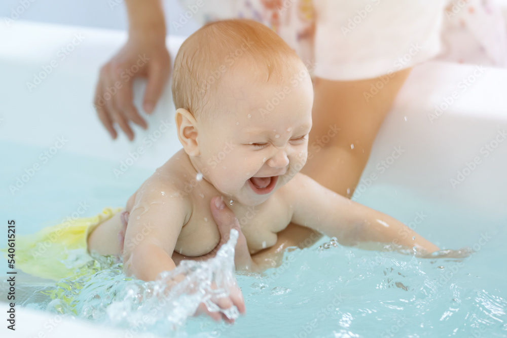 在父亲的帮助下，女婴探索新事物，在浴缸里用水洗澡。女孩和被逗乐的前任在一起