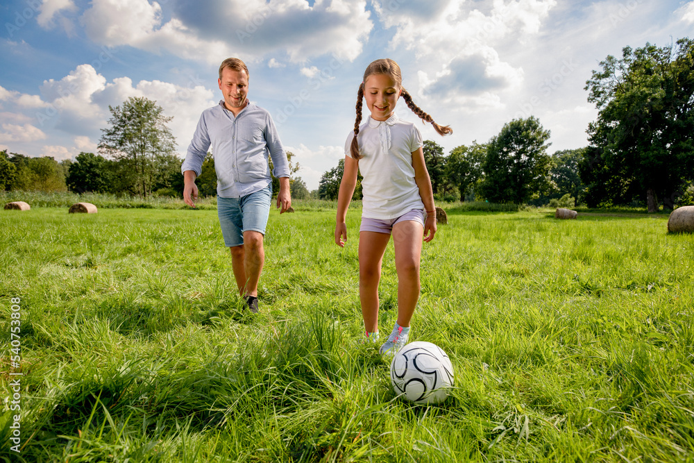 父女俩踢足球，在户外共度时光