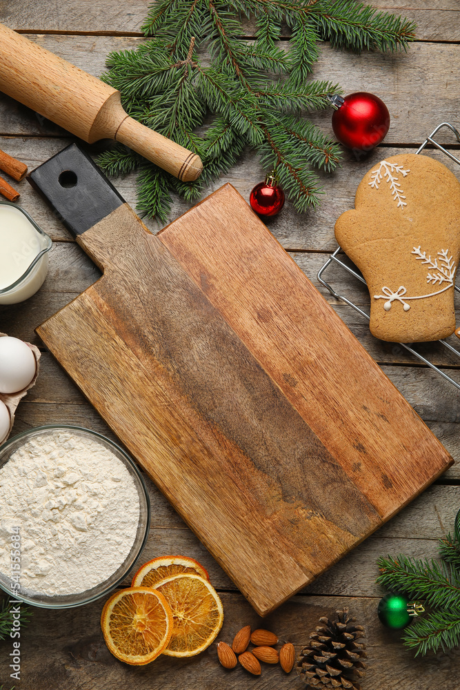 在木质背景上制作圣诞饼干的砧板、杉枝和配料，cl