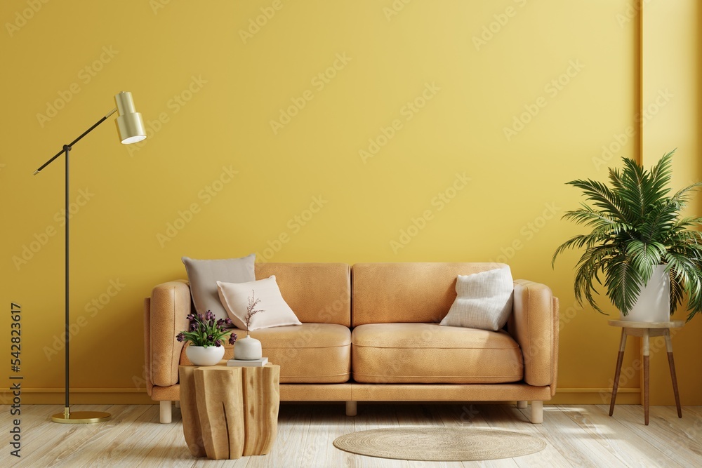 黄色墙壁的室内客厅配有橙色皮沙发，装饰简约。