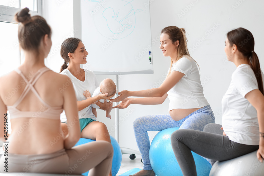 带着婴儿和孕妇在健身房训练的女教练