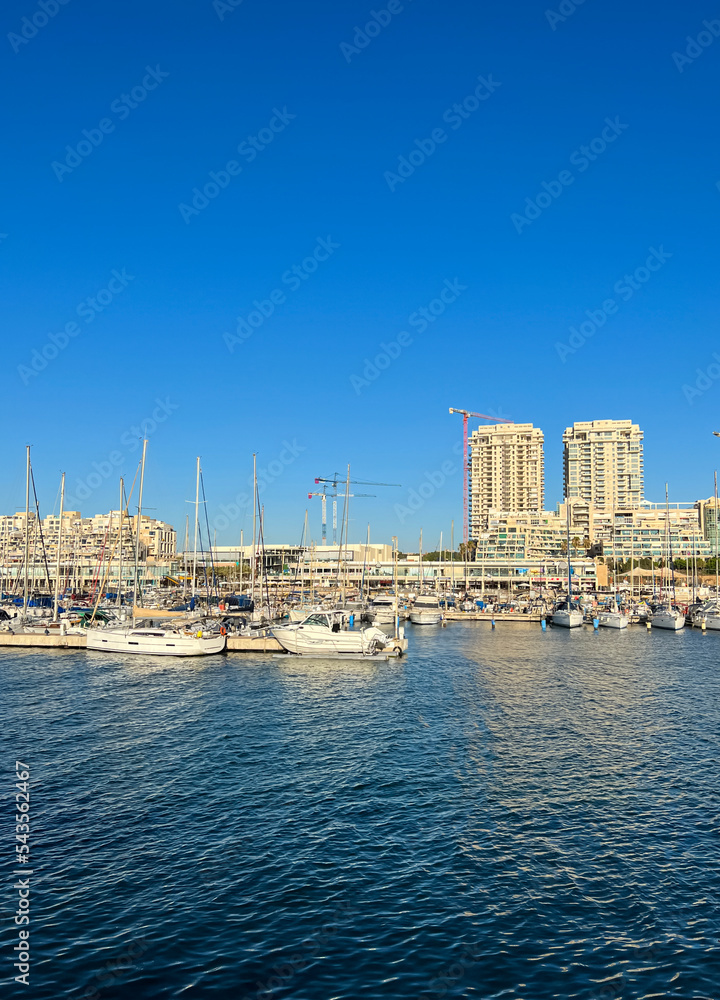 晴天游艇停泊在城市海湾