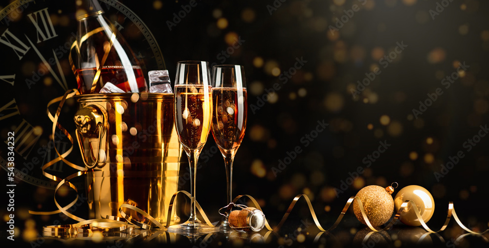 新年快乐！金色水桶，配香槟，两杯，黑色背景上有一条金色蛇形
