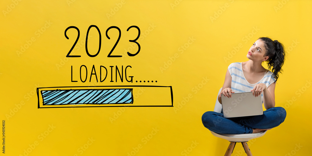 用笔记本电脑与年轻女性一起迎接2023年的新年