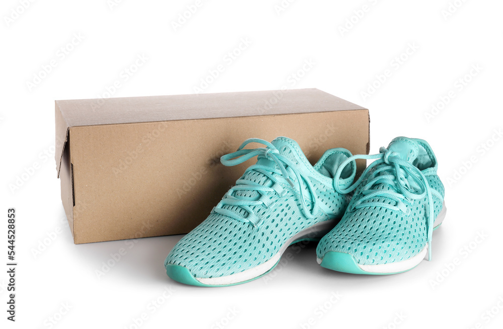 Cardboard box with blue running shoes on white background