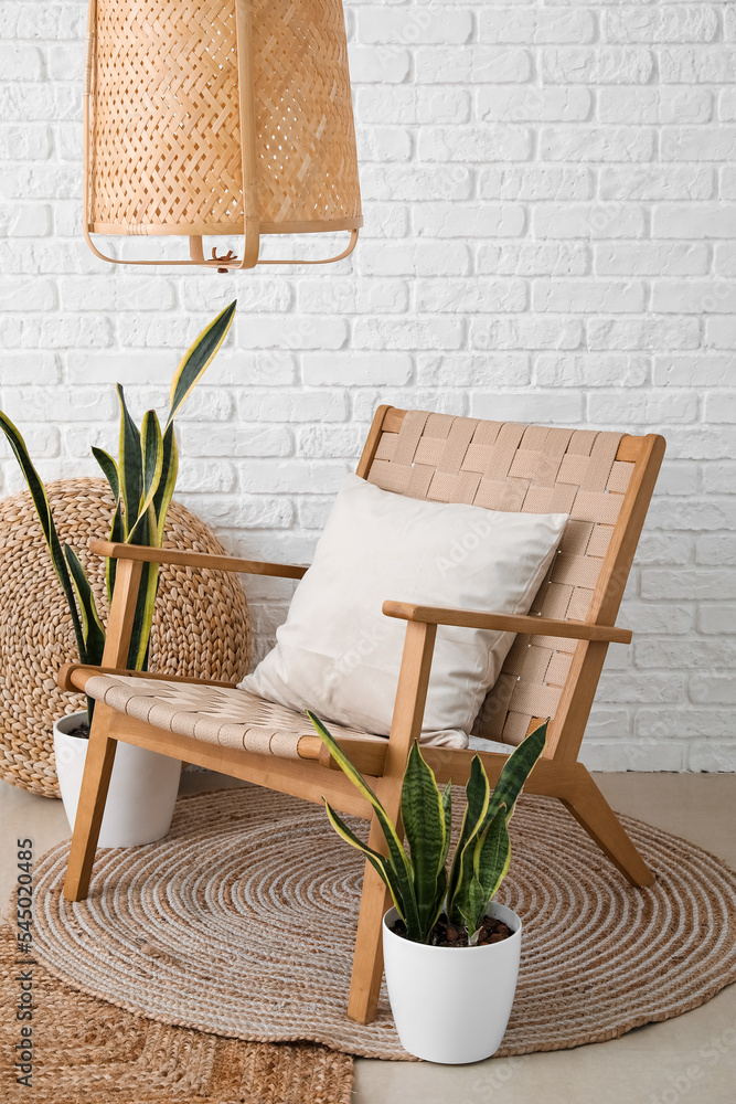 带木制扶手椅、沙发和室内植物的浅色客厅内部