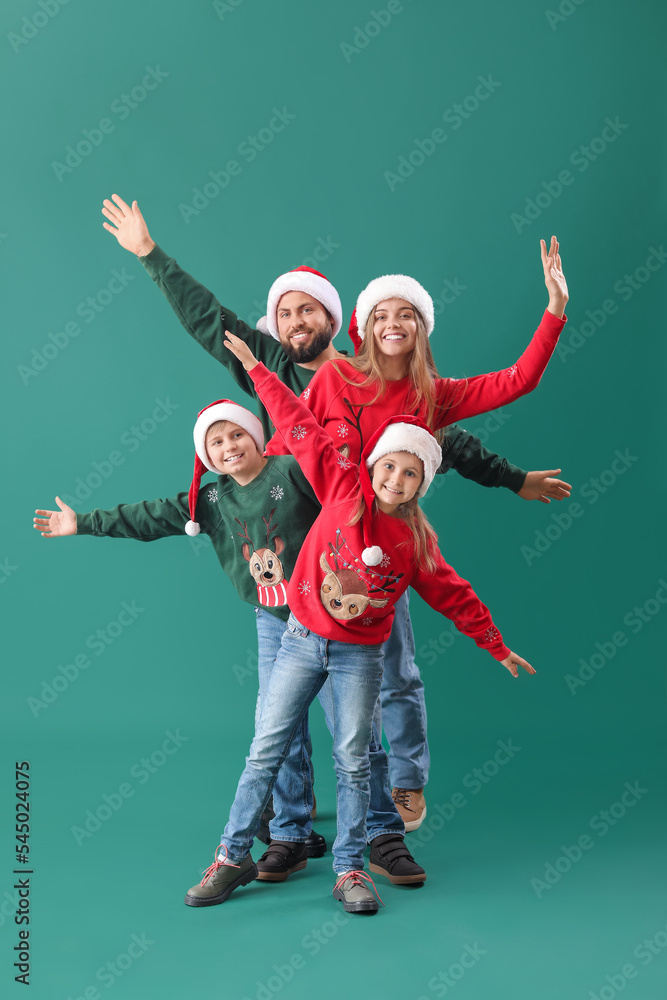 绿色背景戴圣诞老人帽的幸福家庭