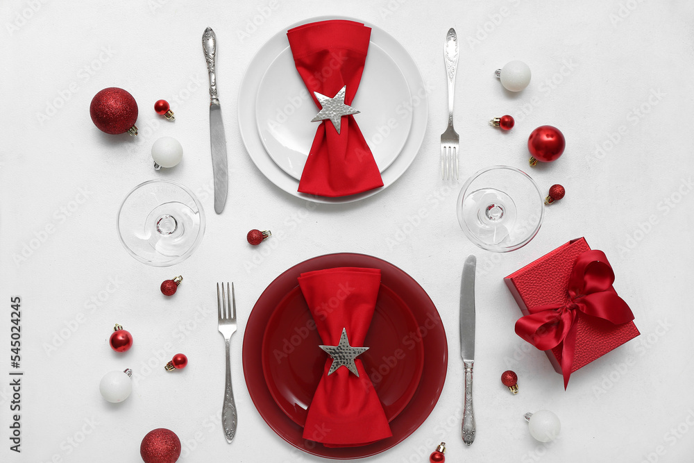 漂亮的餐桌布置，白色背景上有红色圣诞球和礼物