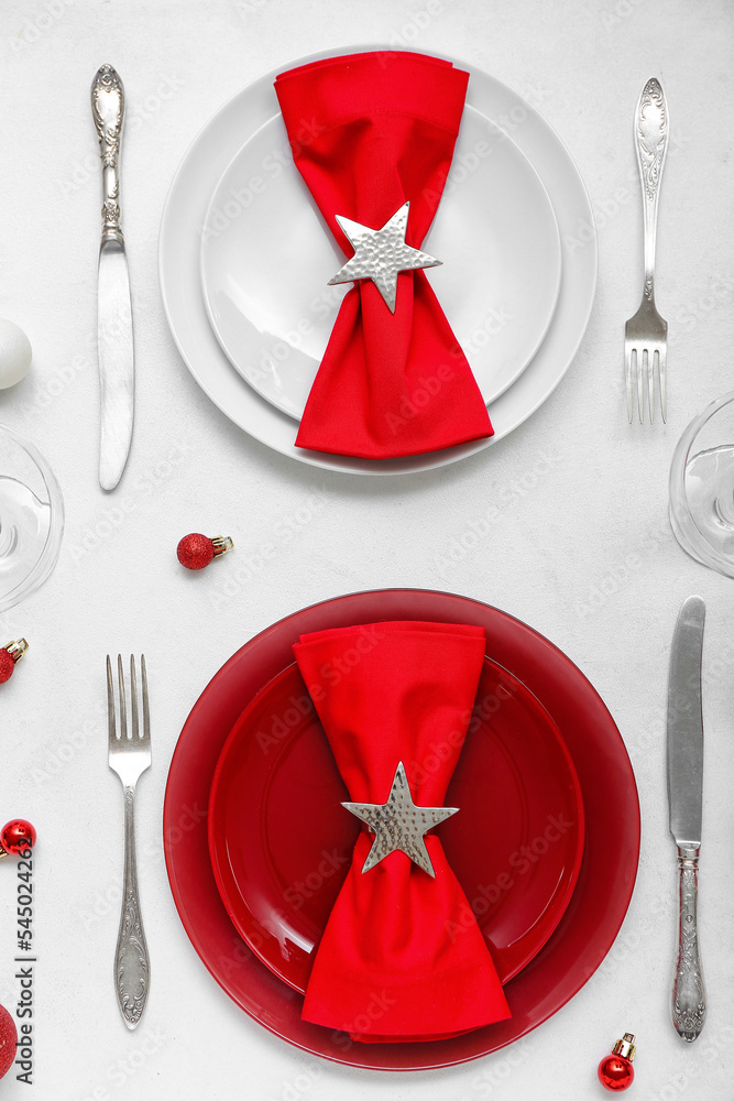 Beautiful table setting with red Christmas balls on white background