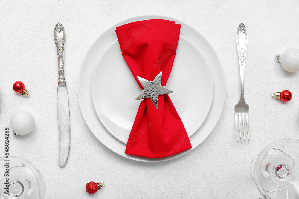 漂亮的餐桌布置，白色背景上有圣诞球和红色餐巾