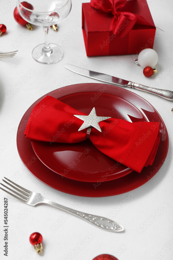 漂亮的餐桌设置，红色盘子、圣诞球和白底礼物，特写