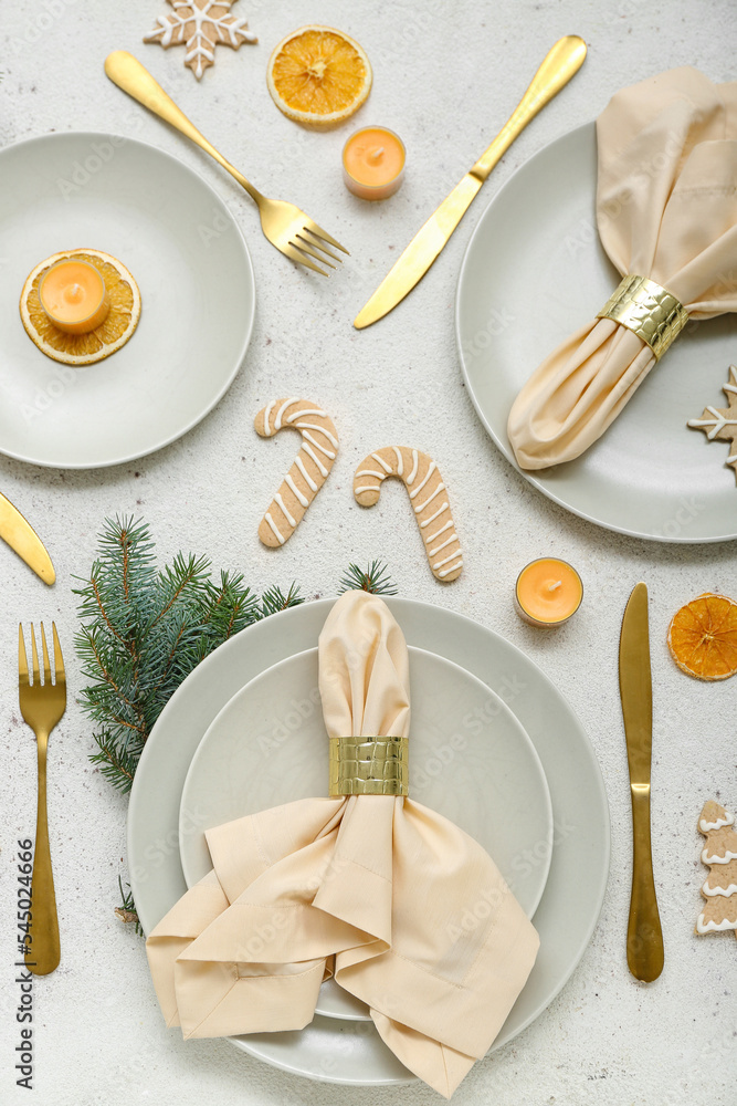 美丽的餐桌布置，白色背景上有圣诞树枝、饼干和柠檬干