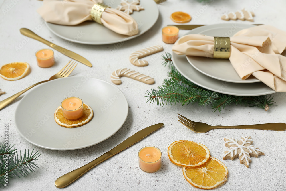 美丽的餐桌布置，白色背景上有圣诞树枝、饼干和干柠檬，clo