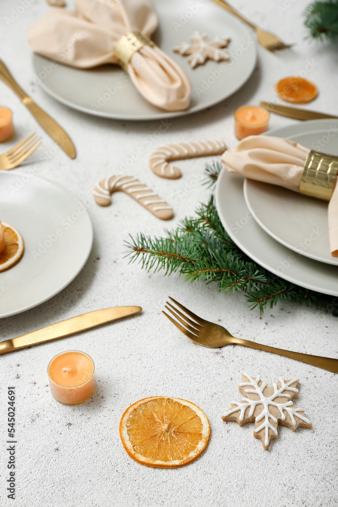 美丽的餐桌布置，白色背景上有圣诞树枝、饼干和柠檬干，clo