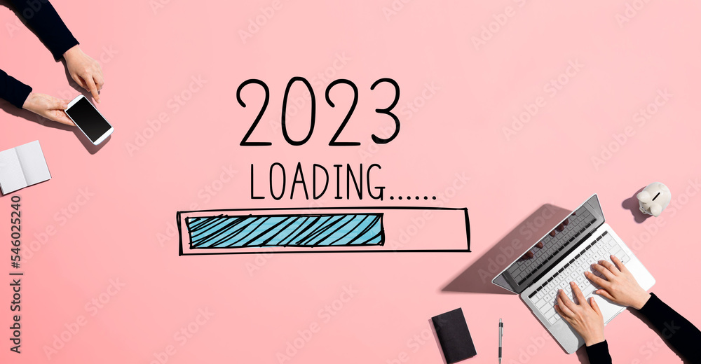 在2023年的新一年里，人们一起使用笔记本电脑和手机工作