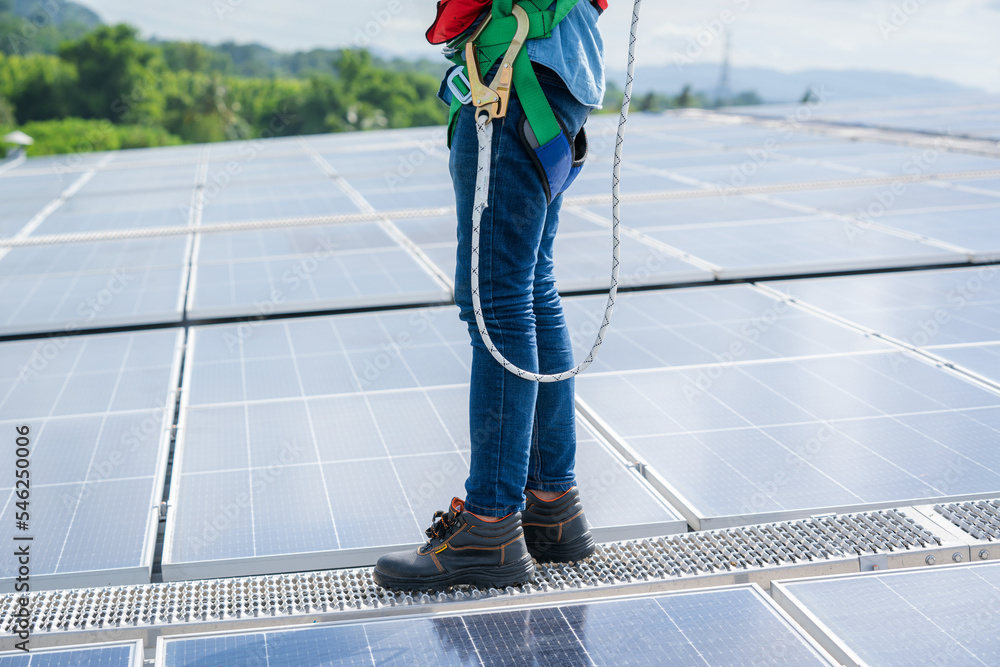 工程师或工人在仓库工厂屋顶安装太阳能电池，选择生态技术