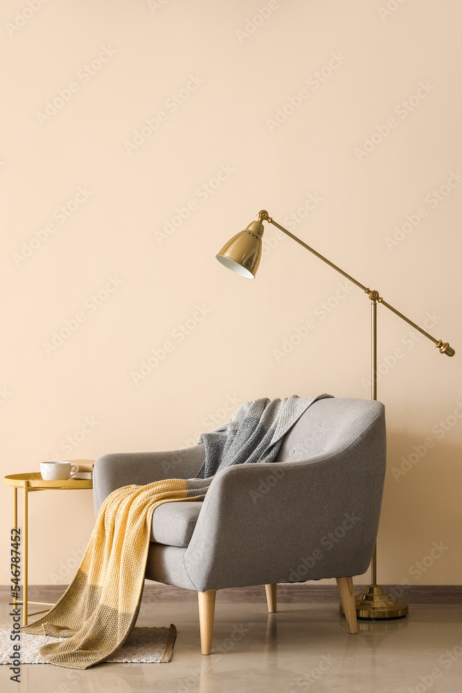 带格子和落地灯的时尚扶手椅，靠近彩色墙壁