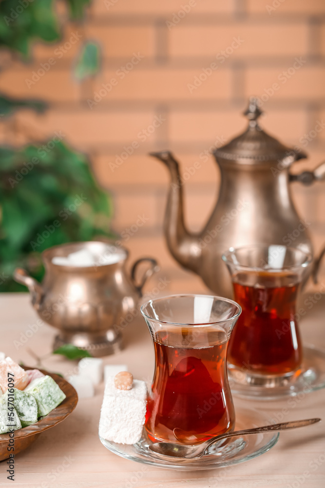 房间桌子上的Saucer配一杯土耳其茶和甜点，特写