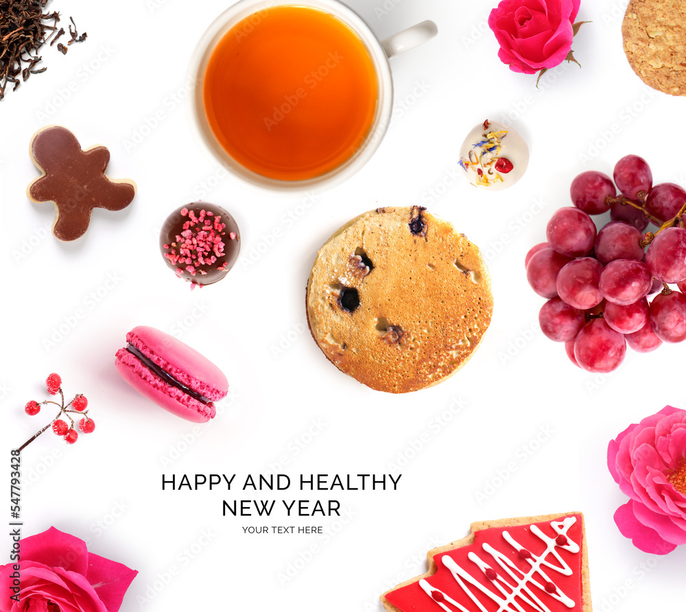 Creative concept of Christmas card made of grapes,cookies, chocolate and dry tea on the white backgr
