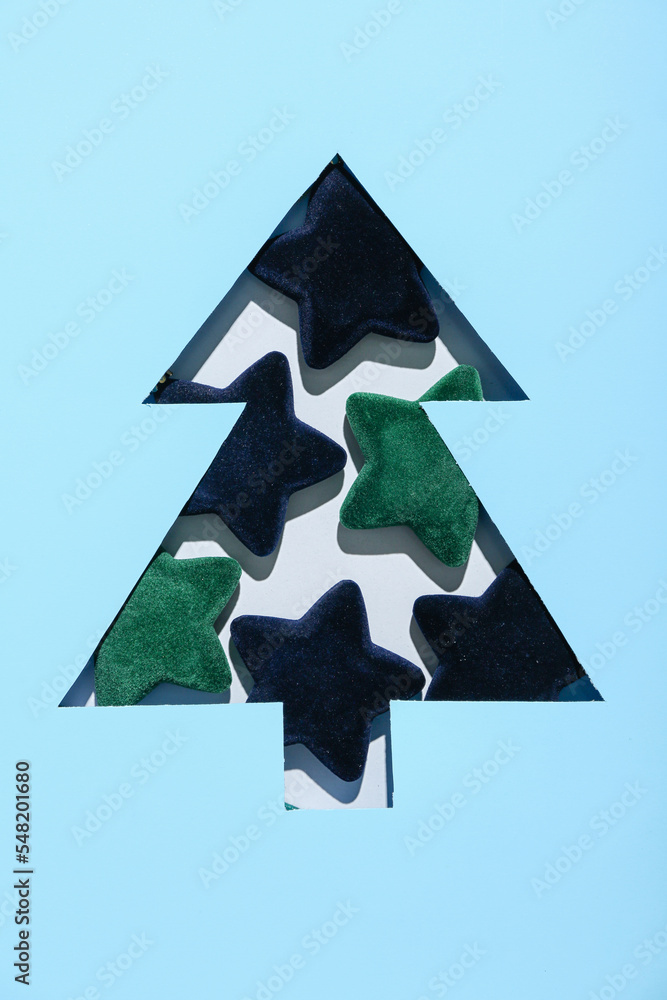 剪成带星星的圣诞树形状的蓝色纸，俯视图