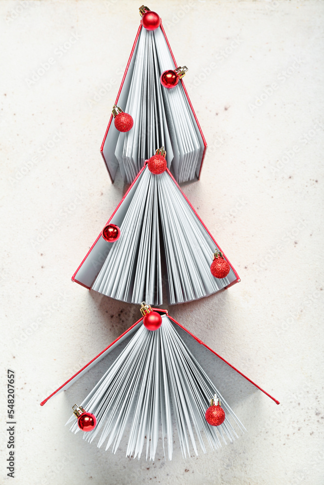 由书籍和球在浅色背景下制成的圣诞树