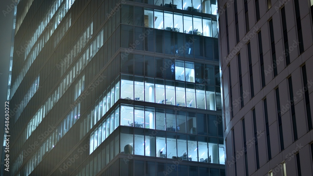 夜晚的城市现代办公楼。公司大楼照明办公室的视图。Bl