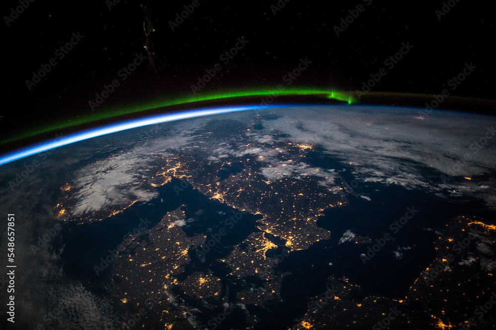 从地球上空俯瞰斯堪的纳维亚半岛的夜晚。波罗的海北部上空的绿色极光