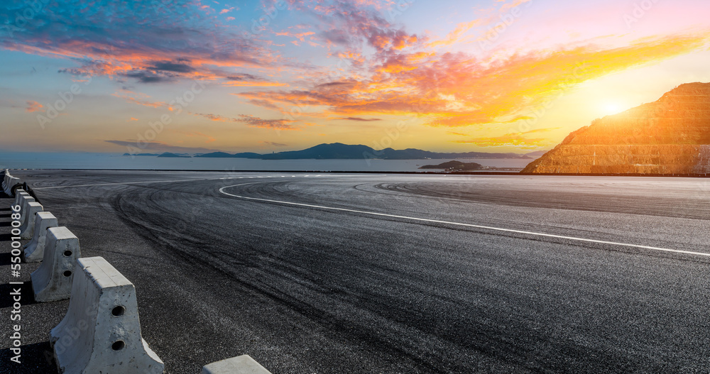 Empty asphalt road by the sea. Road and mountain with sea at sunset.