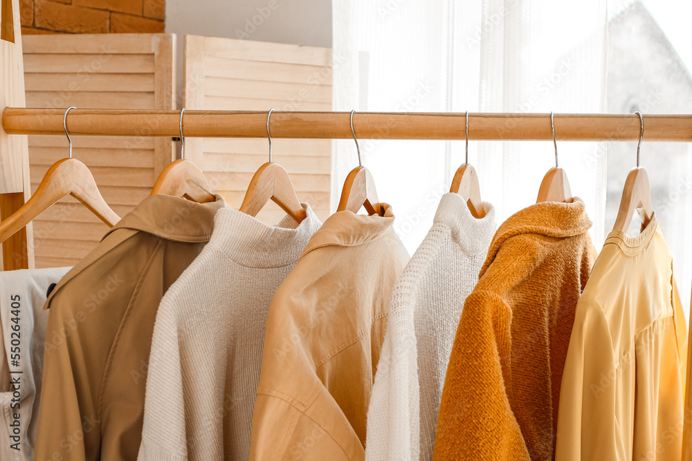 Rack with trendy clothes in room, closeup