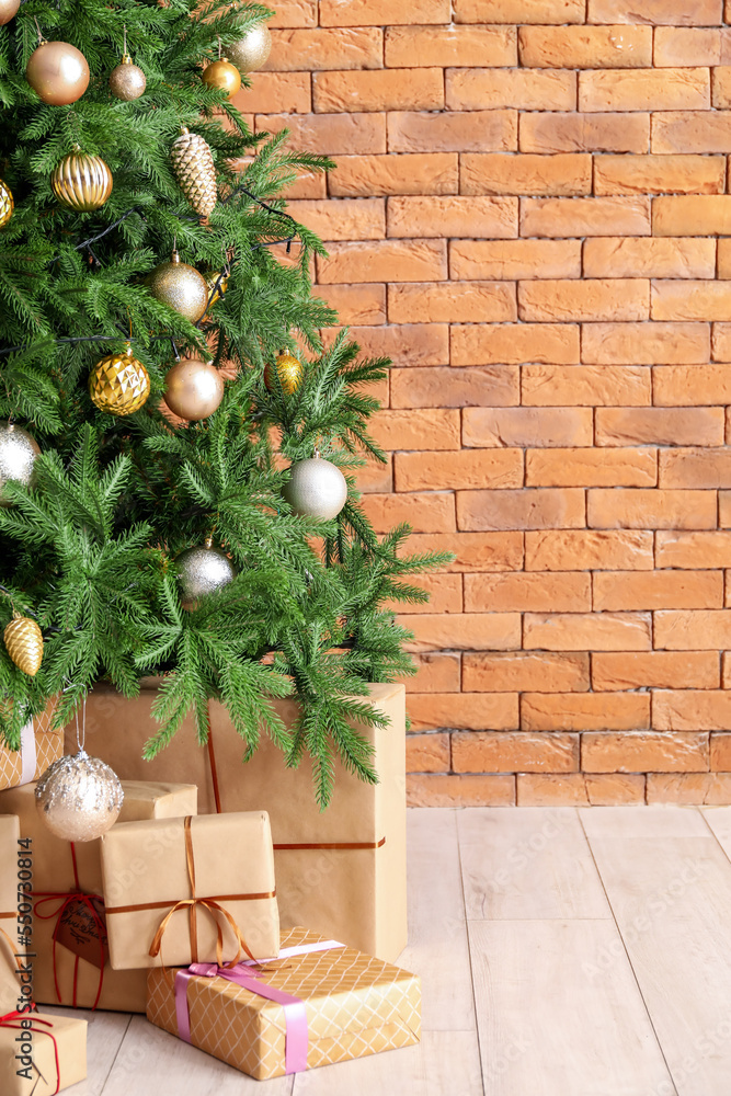 砖墙附近装饰有礼物的圣诞树