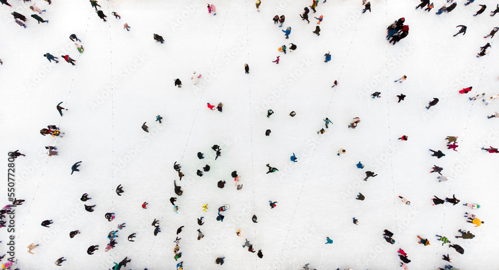 人们在露天溜冰场滑冰。俯视图。许多人在溜冰场的冰上滑冰。空中