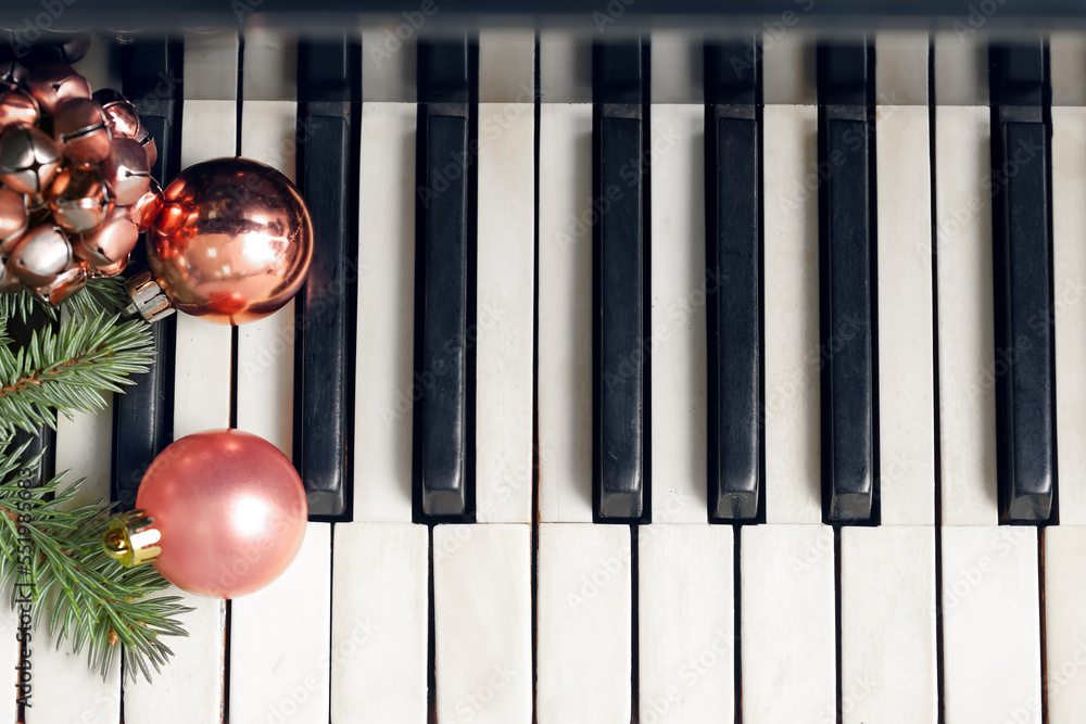 钢琴键上的圣诞球、铃铛和冷杉树枝，俯视图