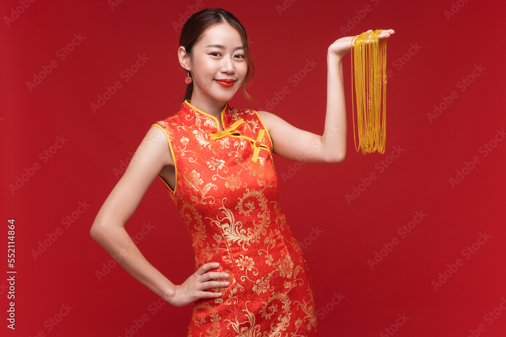 年轻的亚洲女性，身穿红色背景金项链的奇装异服，代表中国人