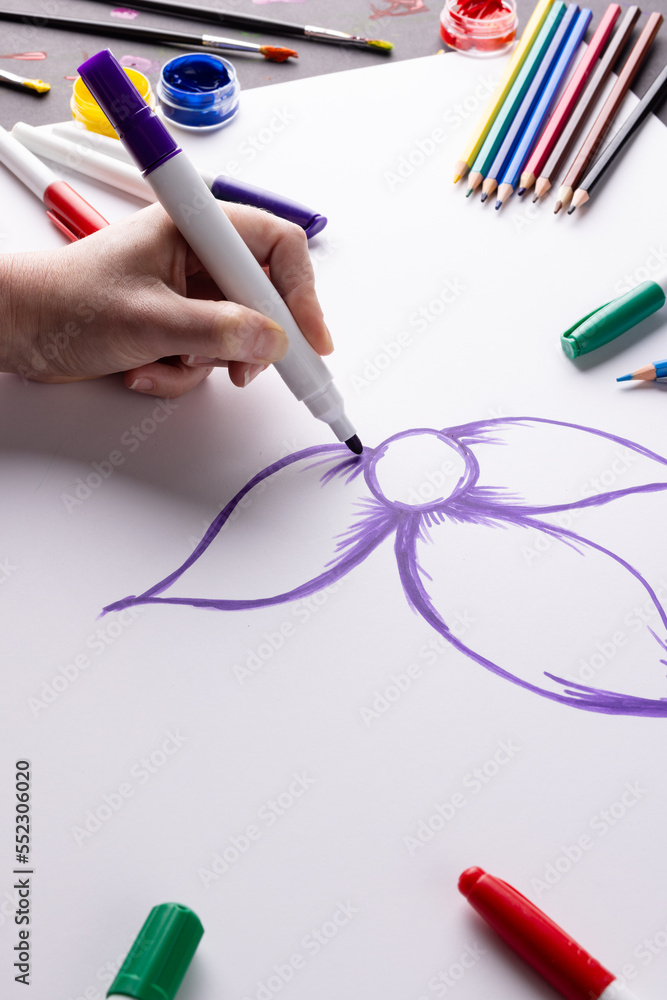 在纸上手绘紫色花朵的垂直图像和桌面上的艺术材料，复制空间
