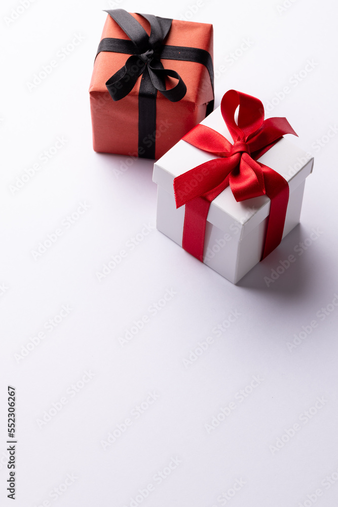 Vertical of white and red gifts with red and black ribbons, on white background with copy space