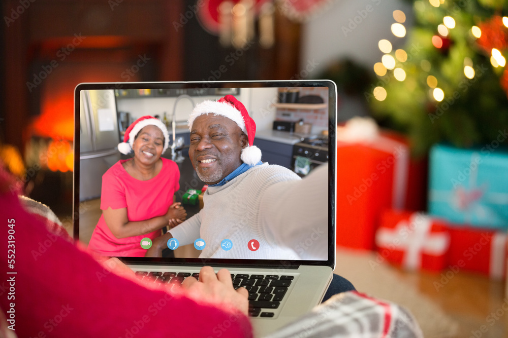 Caucasian woman having christmas video call with senior african american couple