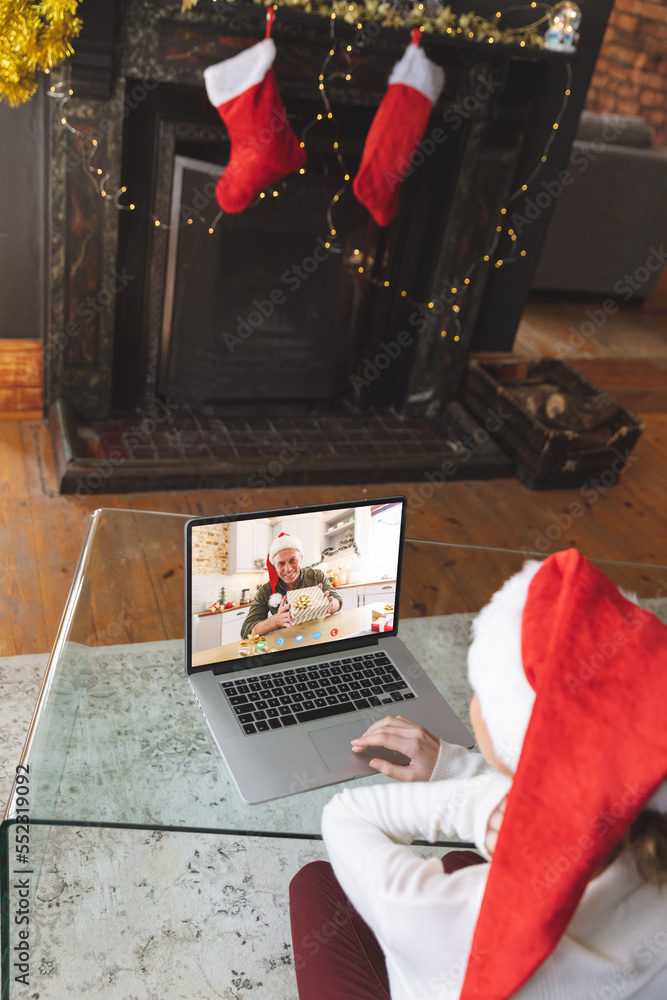 戴着圣诞老人帽的白人妇女与快乐的白人男子进行圣诞笔记本电脑视频通话