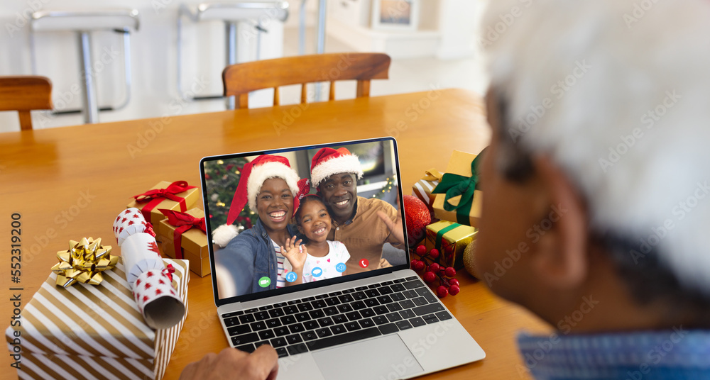 戴着圣诞老人帽的混血男子与幸福的非裔美国人家庭进行视频通话