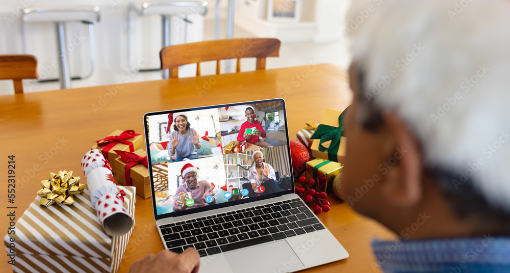 Biracial man with santa hat having video call with happy diverse friends