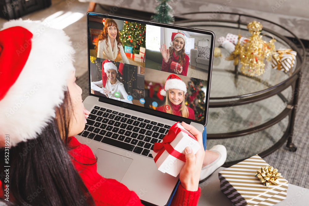 戴着圣诞老人帽的高加索妇女与快乐的高加索朋友视频通话